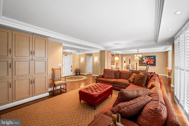 living room with crown molding, wood-type flooring, a raised ceiling, and a chandelier