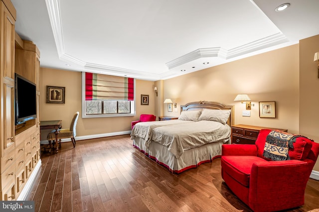 bedroom with a tray ceiling, ornamental molding, and dark hardwood / wood-style floors