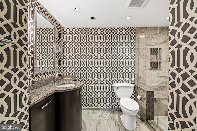 bathroom with vanity, toilet, and an enclosed shower