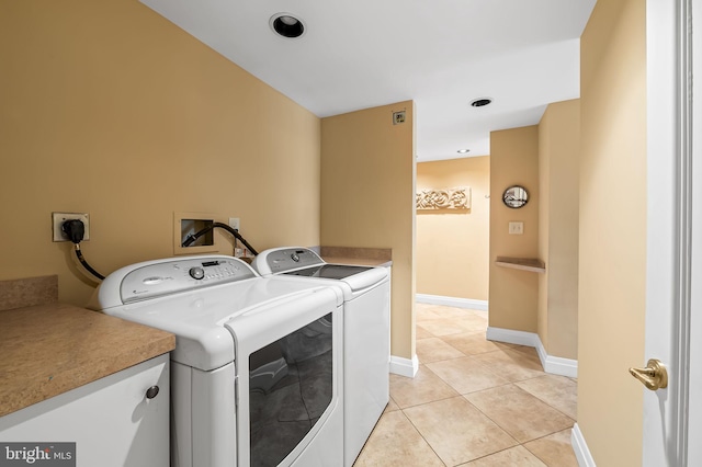 laundry area with independent washer and dryer and light tile patterned flooring