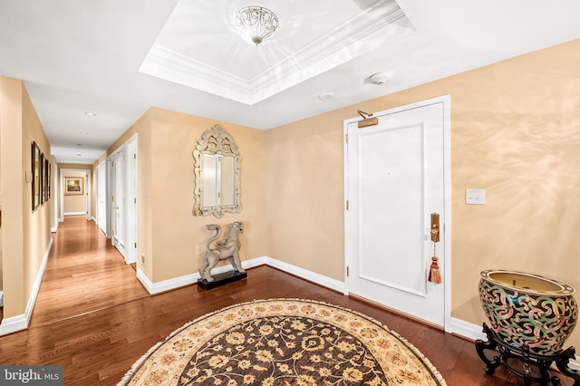 entrance foyer featuring hardwood / wood-style flooring, crown molding, and a raised ceiling