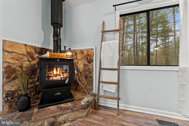 interior details featuring hardwood / wood-style floors and a wood stove