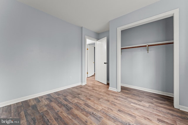 unfurnished bedroom with hardwood / wood-style flooring and a closet