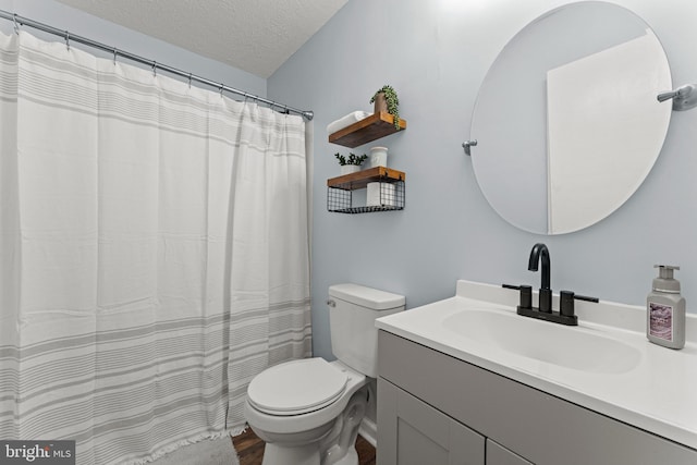 bathroom with vanity, toilet, and a textured ceiling