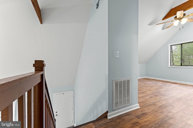 staircase with hardwood / wood-style floors, ceiling fan, and vaulted ceiling