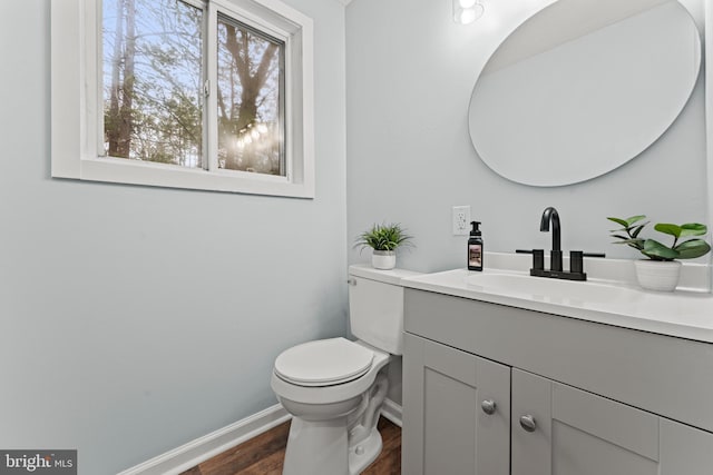 bathroom with hardwood / wood-style flooring, vanity, and toilet