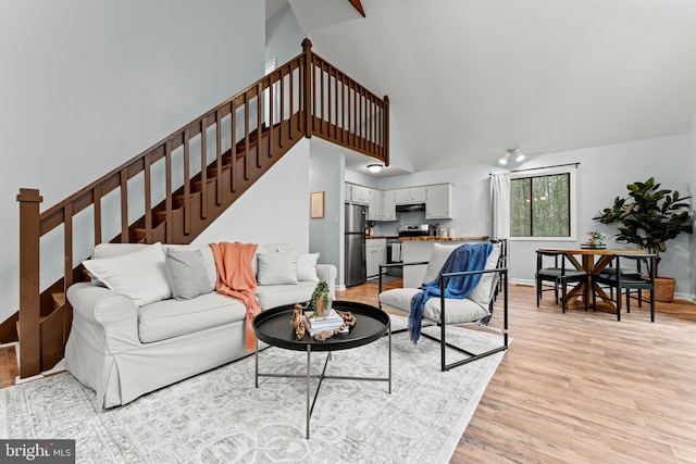 living room featuring high vaulted ceiling and light wood-type flooring