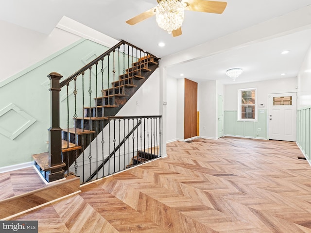 stairway featuring ceiling fan and parquet floors