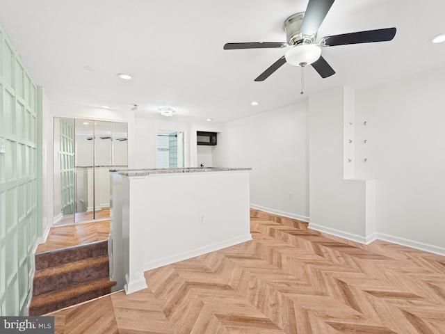 kitchen featuring light parquet flooring, white cabinets, and light stone counters