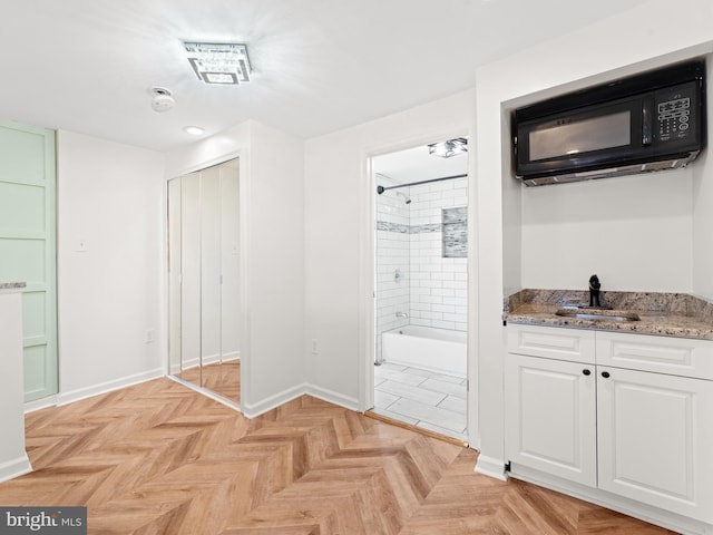 bathroom featuring parquet flooring, vanity, and tiled shower