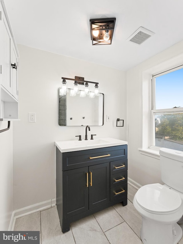 bathroom with tile patterned flooring, vanity, and toilet