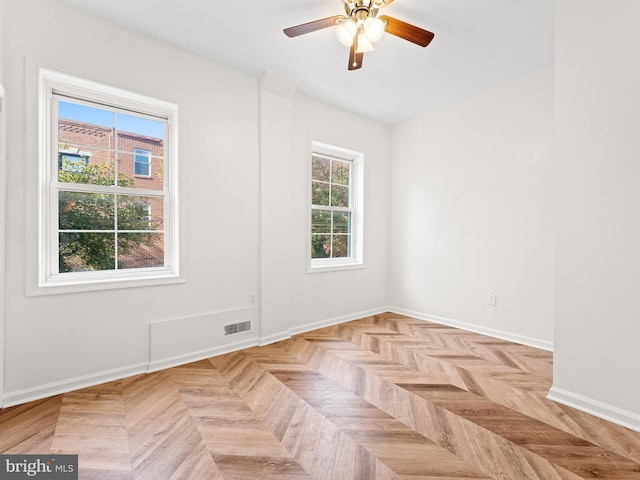 spare room featuring ceiling fan and light parquet flooring