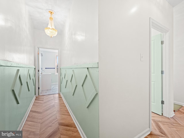 bathroom with parquet flooring and an inviting chandelier