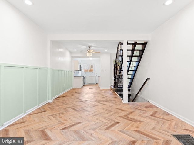 unfurnished room with ceiling fan and light parquet flooring