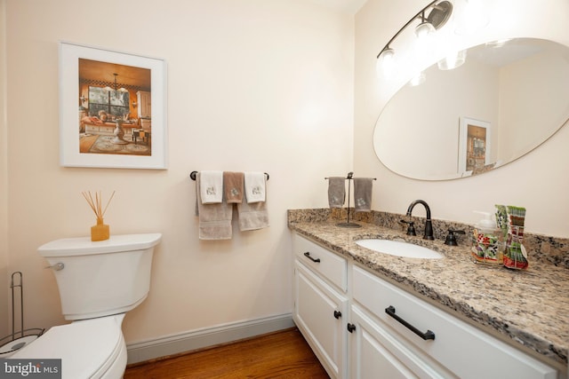 bathroom featuring toilet, hardwood / wood-style flooring, and vanity