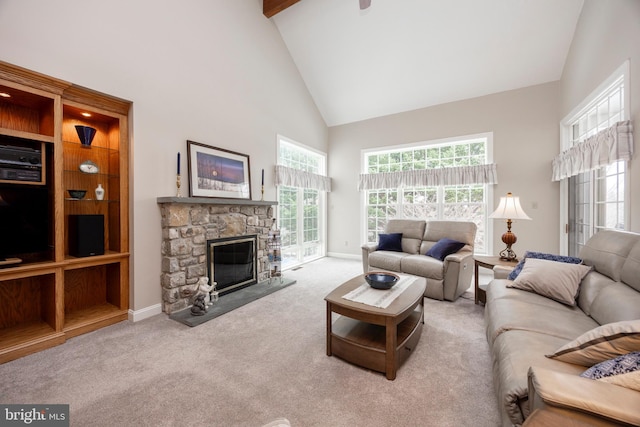 living room featuring high vaulted ceiling, light carpet, a fireplace, and a wealth of natural light