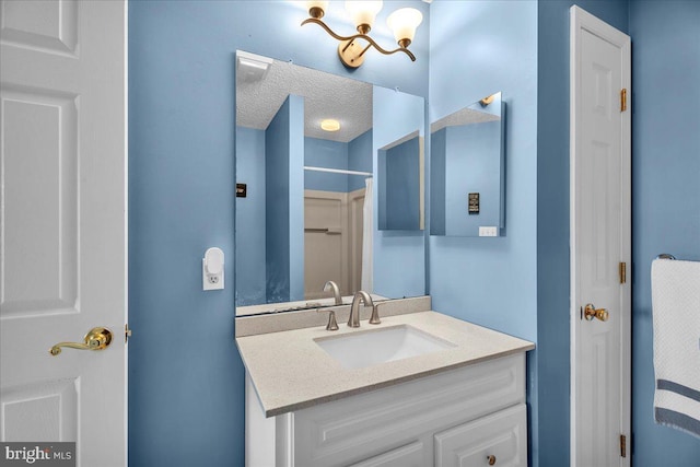 bathroom featuring a textured ceiling and vanity