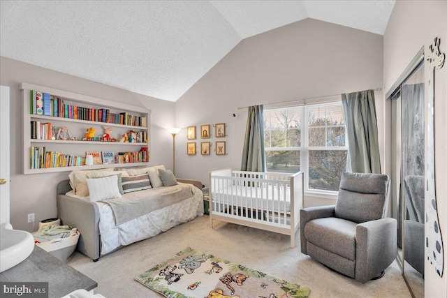 bedroom with light carpet, a textured ceiling, a nursery area, and lofted ceiling