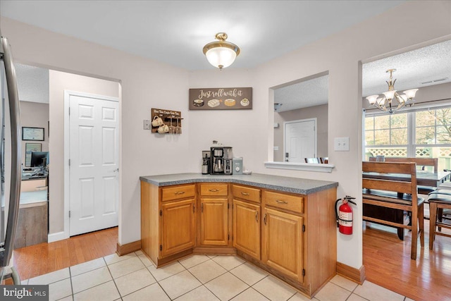 kitchen with a notable chandelier, light tile patterned flooring, and a textured ceiling