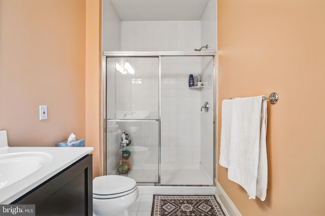 bathroom featuring toilet, tile patterned flooring, vanity, and a shower with shower door