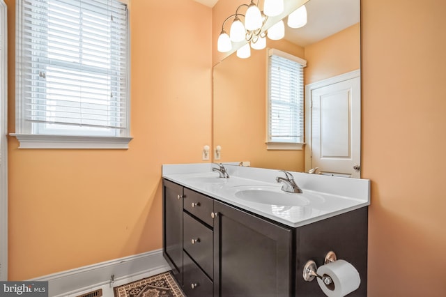 bathroom featuring a notable chandelier and vanity