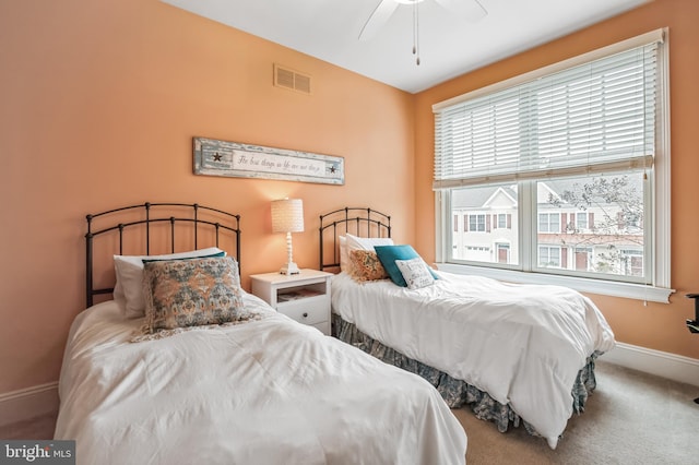 bedroom with ceiling fan, carpet, and multiple windows