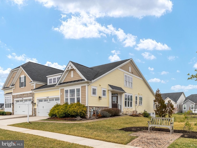 view of front of property with a front lawn, stone siding, concrete driveway, an attached garage, and a shingled roof