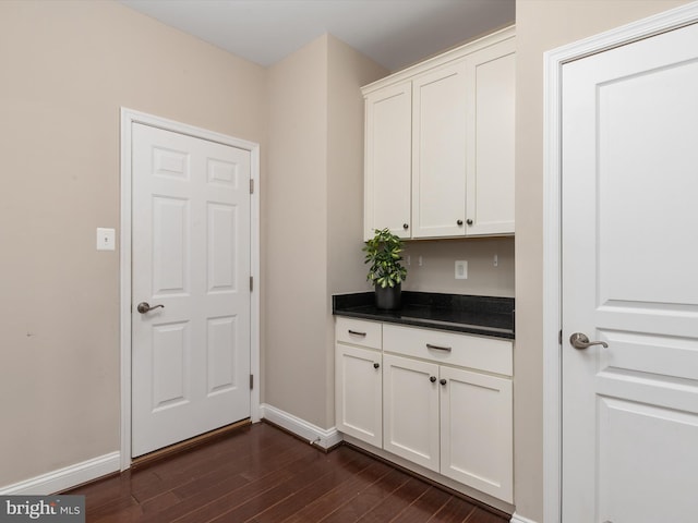 interior space with baseboards and dark wood-style floors