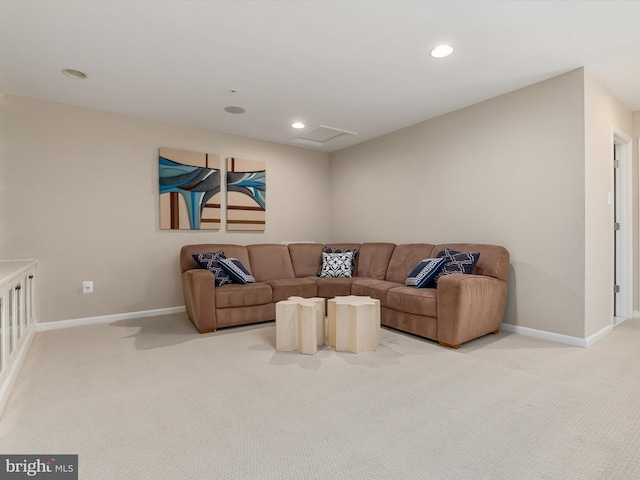 living area featuring baseboards, light carpet, and attic access