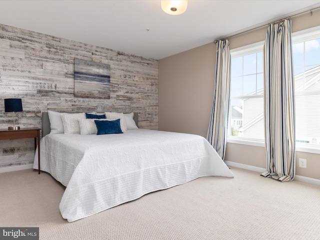 bedroom featuring an accent wall, carpet flooring, and baseboards