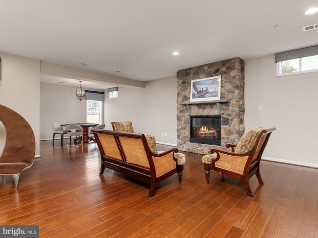 living room with visible vents, a fireplace, baseboards, and wood finished floors