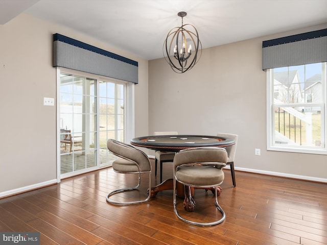 dining space with a chandelier, a healthy amount of sunlight, and wood finished floors