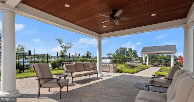 view of patio with a ceiling fan, an outdoor living space, exterior kitchen, and fence