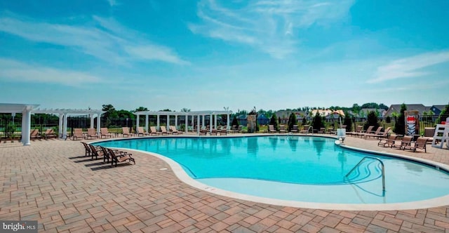 community pool with a patio, fence, and a pergola