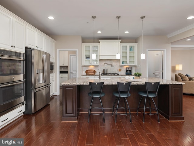 kitchen with white cabinetry, dark wood-type flooring, tasteful backsplash, and appliances with stainless steel finishes