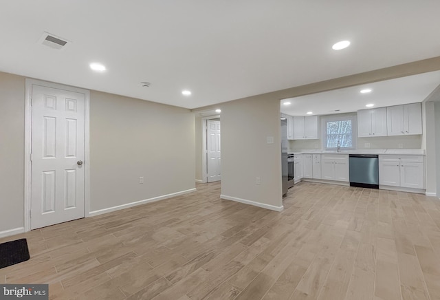 unfurnished living room featuring light hardwood / wood-style floors and sink