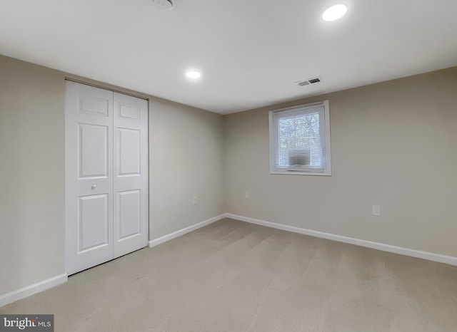 unfurnished bedroom with light carpet and a closet