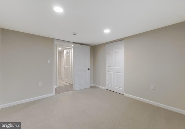 unfurnished bedroom featuring light colored carpet and a closet