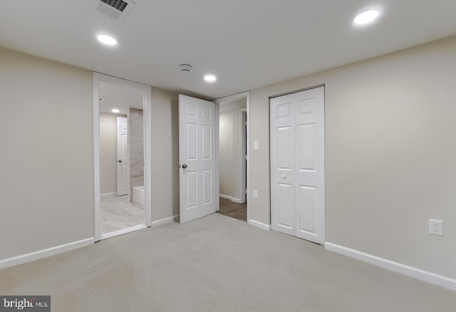 unfurnished bedroom featuring light carpet and a closet