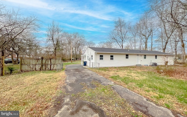 back of house featuring a lawn and central AC