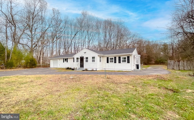 view of front of property featuring a garage and a front lawn