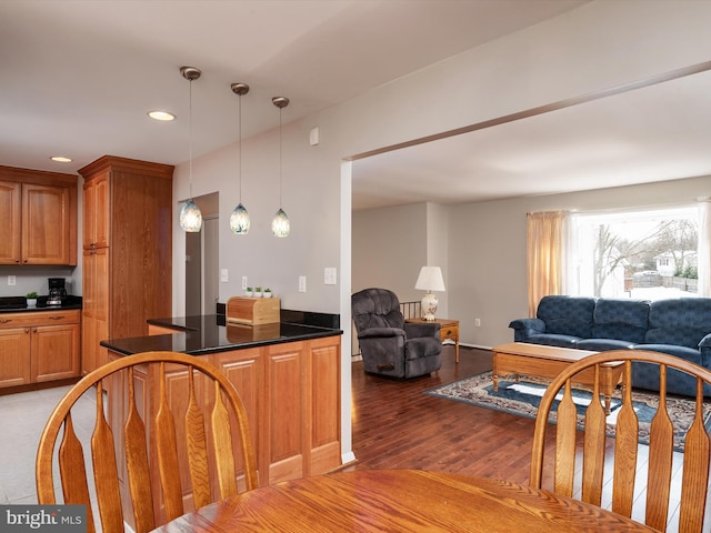 kitchen featuring hanging light fixtures and dark wood-type flooring