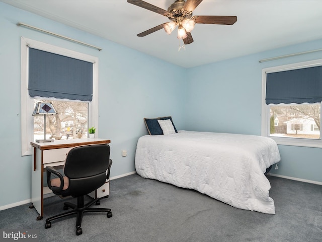 bedroom featuring multiple windows, dark colored carpet, and ceiling fan