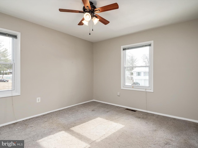 empty room with ceiling fan, carpet flooring, and a wealth of natural light