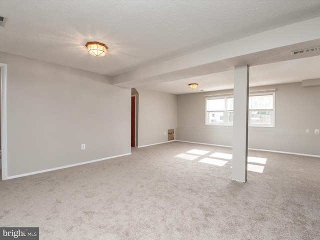 basement with light colored carpet and a textured ceiling