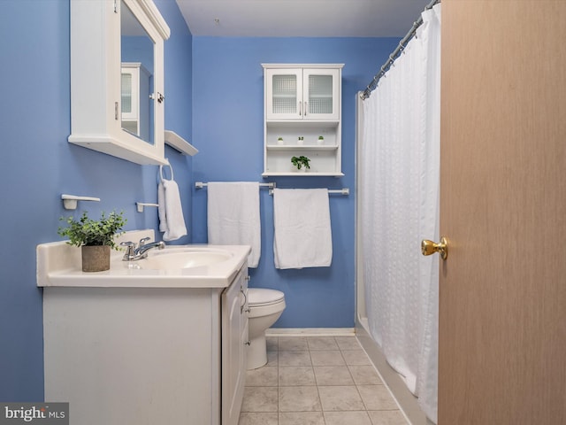 bathroom featuring tile patterned flooring, vanity, toilet, and walk in shower