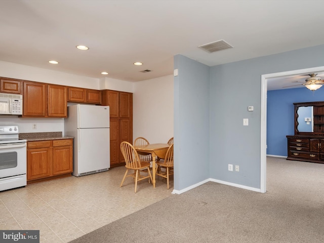 kitchen featuring ceiling fan, light colored carpet, and white appliances