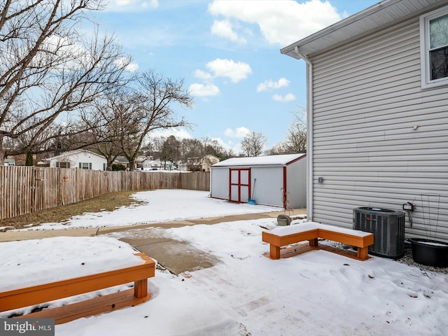 yard covered in snow with cooling unit and a storage unit