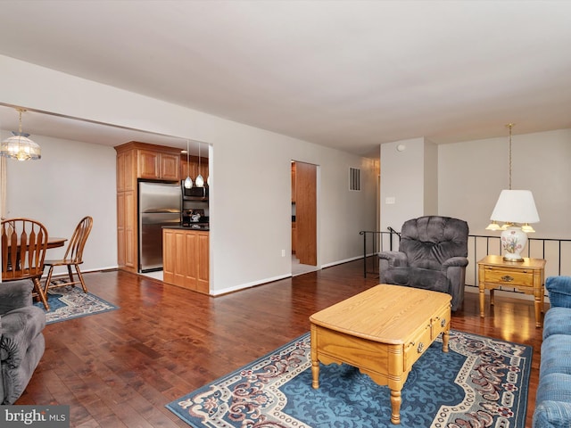 living room featuring dark hardwood / wood-style flooring and a notable chandelier