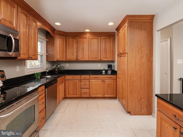 kitchen with dark stone countertops, sink, and appliances with stainless steel finishes